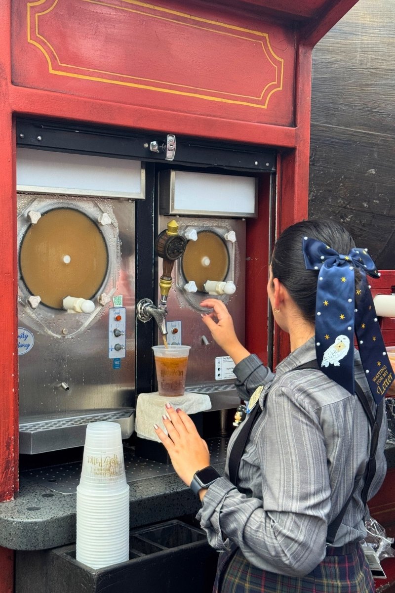 Close-up of cold Butterbeer being poured with its signature foam topping at the Wizarding World of Harry Potter.