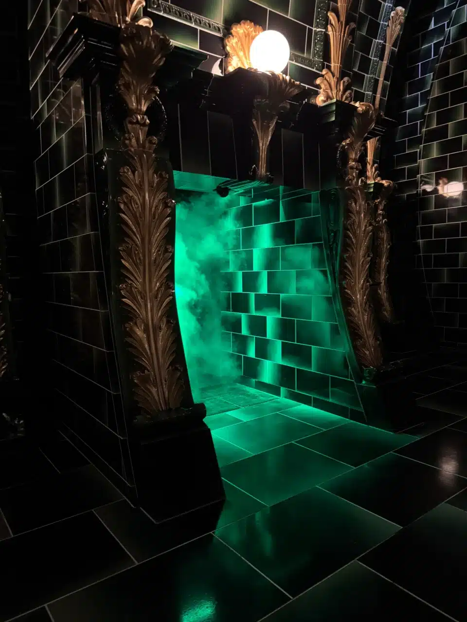 Glowing green Floo Network fireplace in the Battle at the Ministry queue at the Wizarding World of Harry Potter at Epic Universe.