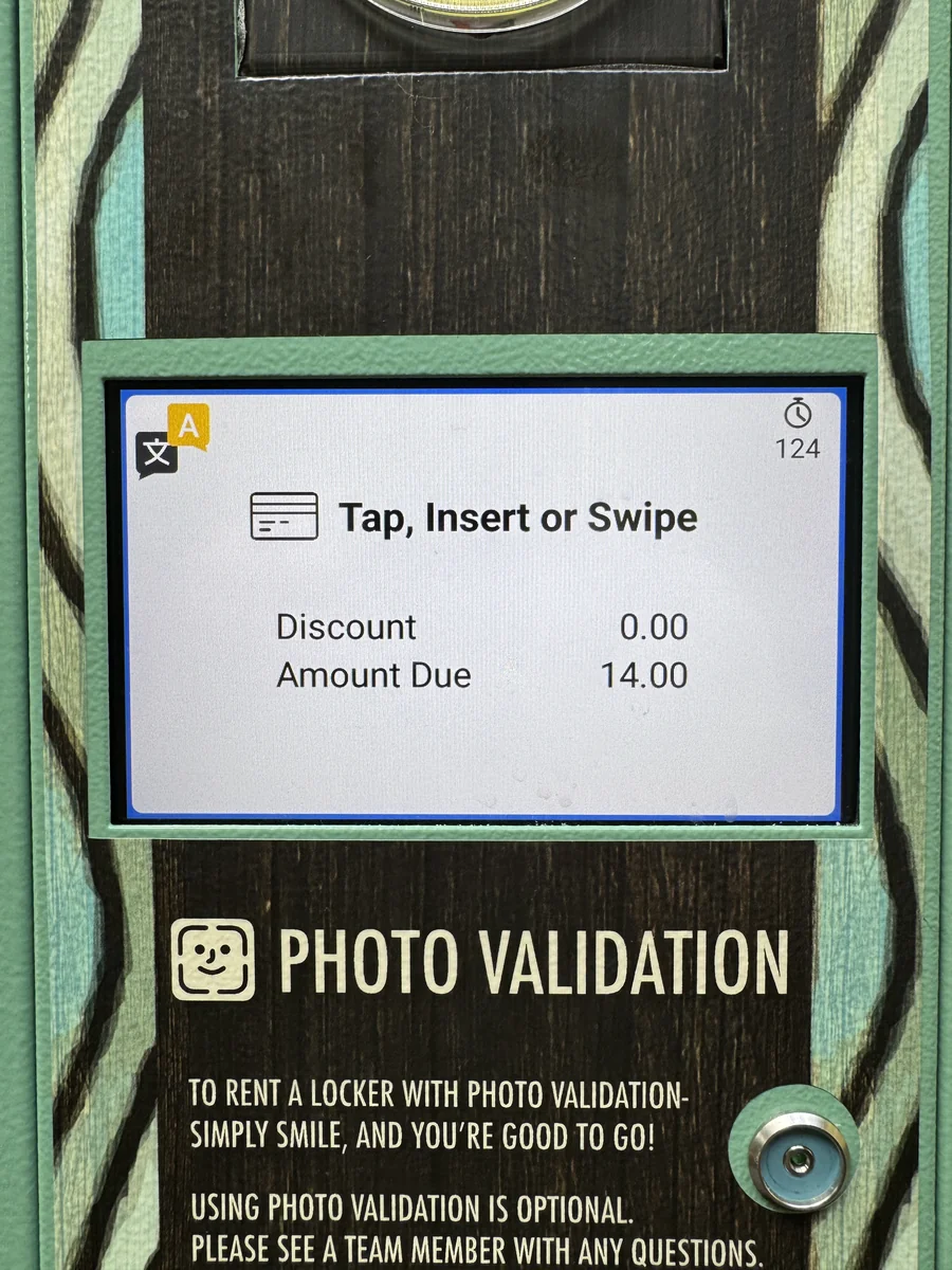 Photo Validation locker kiosk screen at Volcano Bay showing the $14 rental cost