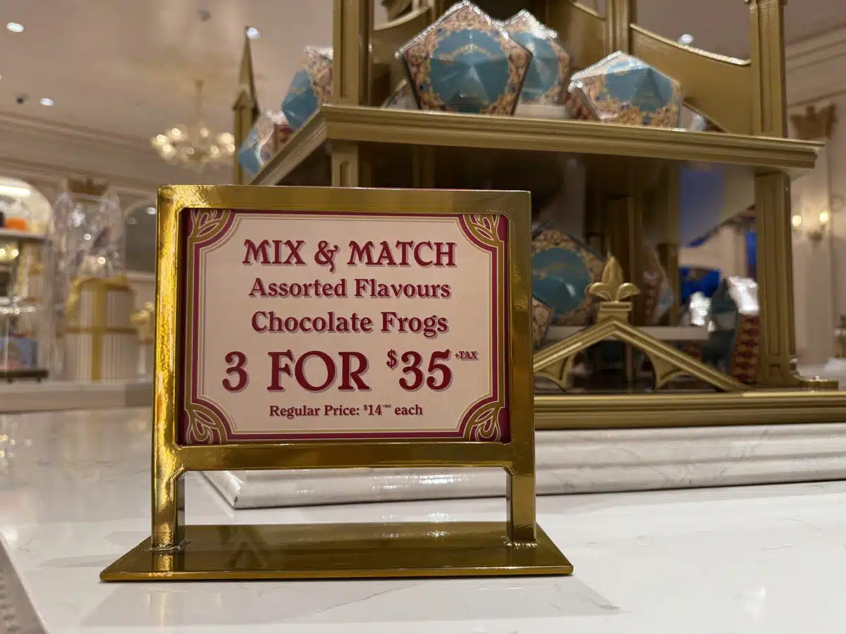 Chocolate Frogs mix and match three for thirty-five dollars sign at Les Galeries Mirifiques Wizarding World of Harry Potter Epic Universe.