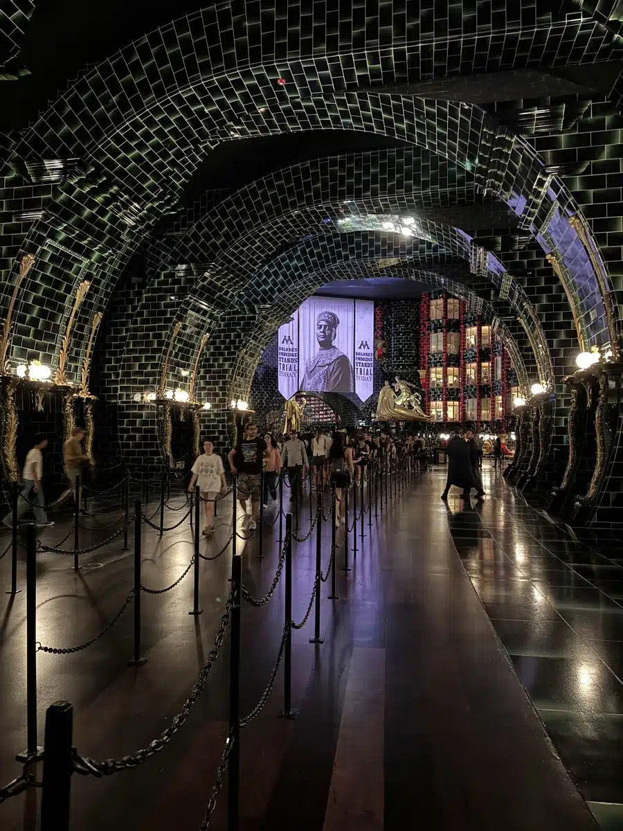 Floo Network tunnel with green tile mosaic walls in the Battle at the Ministry queue at Wizarding World of Harry Potter Epic Universe.