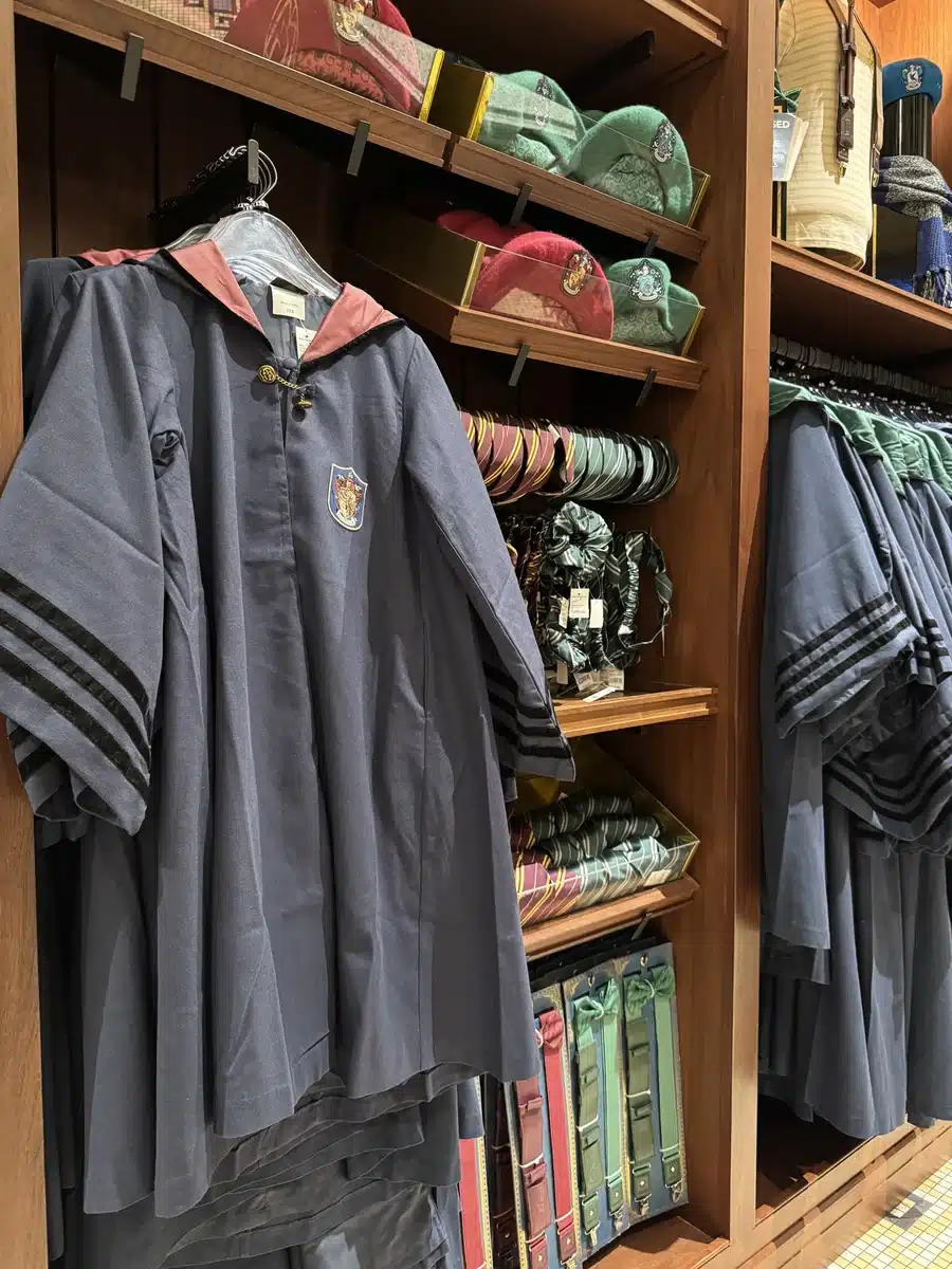 Hogwarts house robes folded in drawers with ties at Les Galeries Mirifiques Wizarding World of Harry Potter Epic Universe.