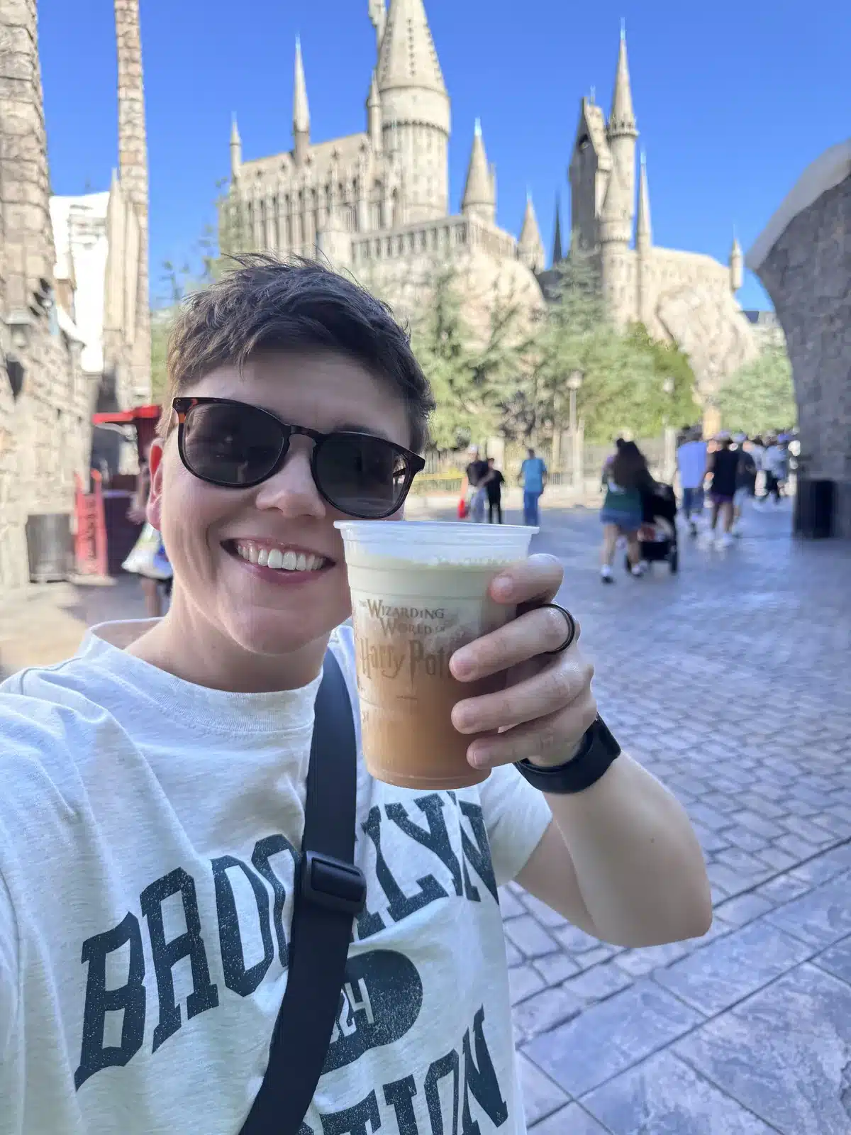 Cora holding a cold Butterbeer in front of Hogwarts Castle in The Wizarding World of Harry Potter at Universal Studios Hollywood