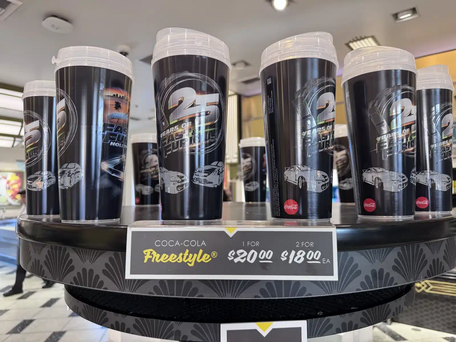Fast & Furious 25th anniversary Coca-Cola Freestyle refillable cups on a display stand with the $20 price sign at Universal Studios Hollywood