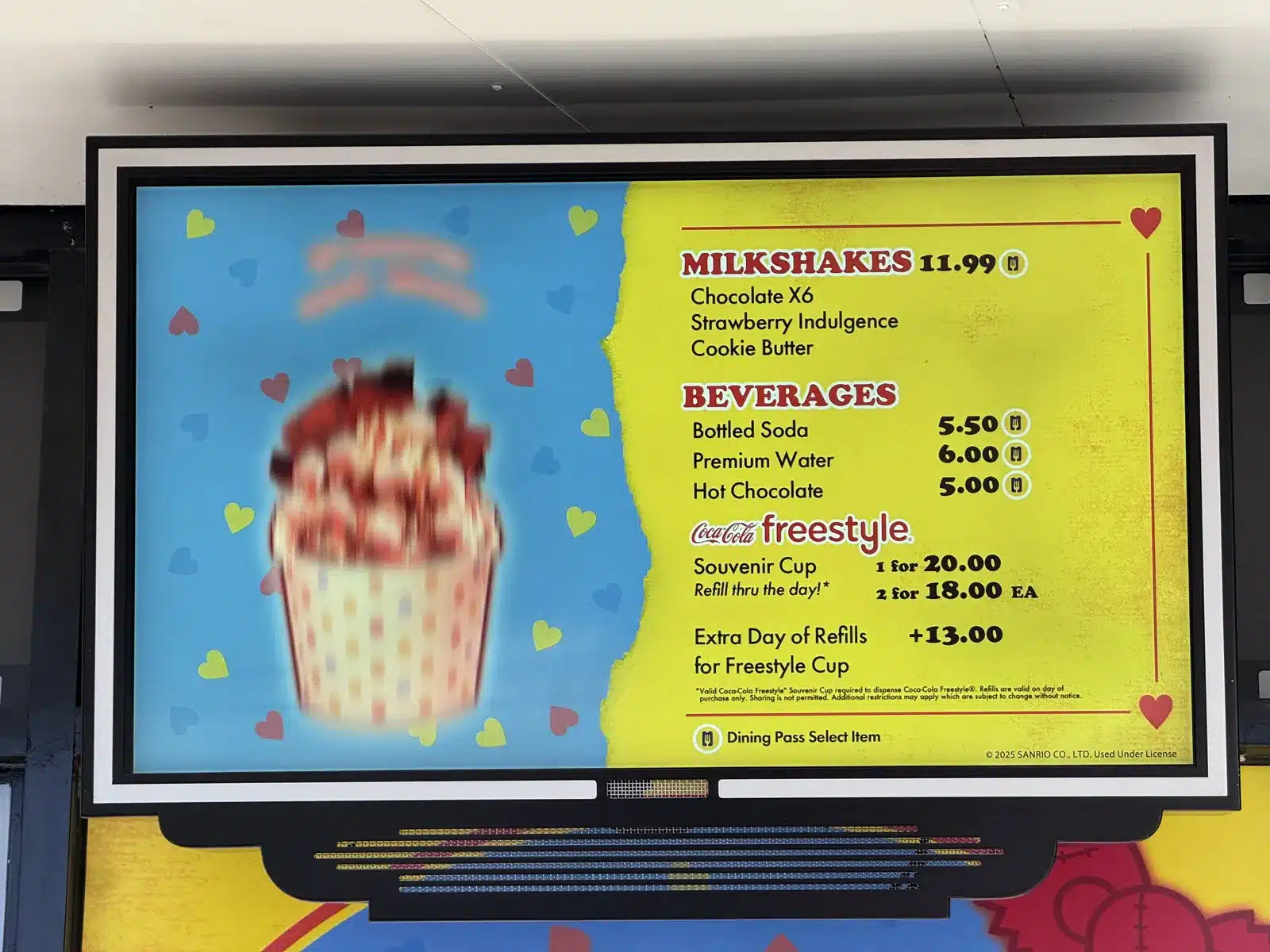Menu board at Universal Studios Hollywood listing the Coca-Cola Freestyle souvenir cup at $20 and an extra day of refills at $13