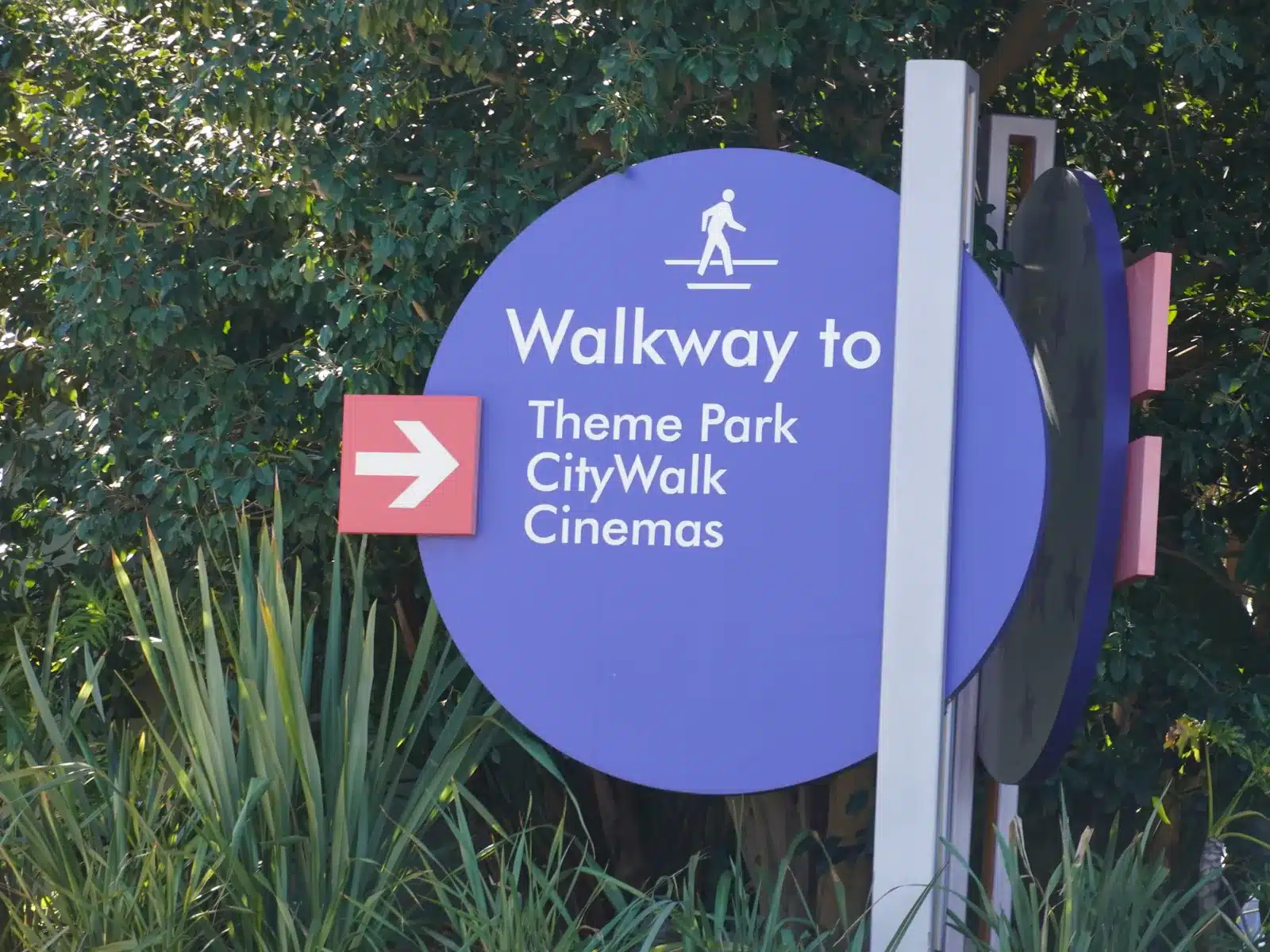 Walkway to Theme Park, CityWalk and Cinemas sign at the top of the hill at Universal Studios Hollywood