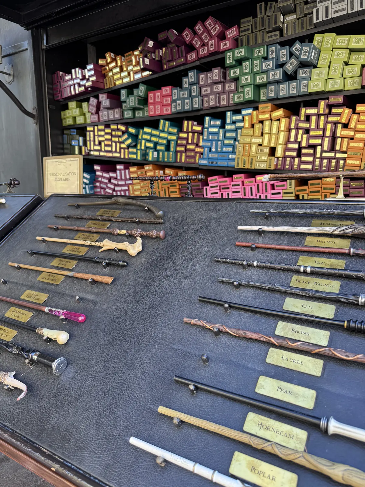 Wand display inside Ollivanders in Hogsmeade at Universal Studios Hollywood with character wands laid out on the counter
